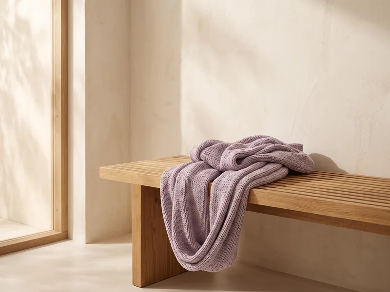 A lavender aerial yoga hammock draped over a wooden bench