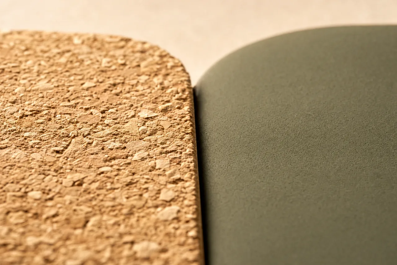 Macro close-up comparing natural cork grain texture against a smooth matte rubber surface