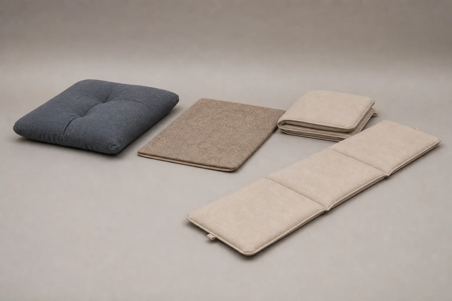 Studio photograph comparing a tufted square zabuton, thin layered wool mat and long segmented foldable meditation mat